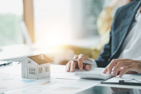 Cropped shot of estate agent using calculator calculate for contract to buy or Stock Photos