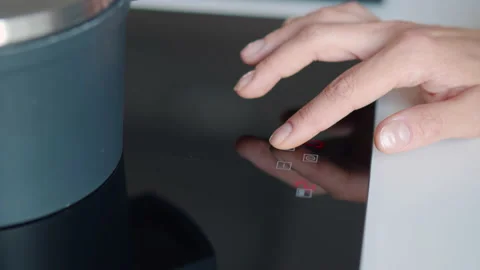 Cropped shot of female hand select function on induction stove panel. Realtime Video stock 204899077