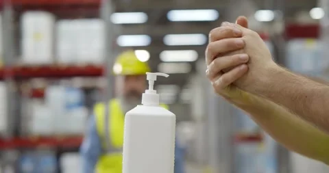 Cropped shot of industrial worker using sanitizer disinfecting hands in Stock Footage 151405735