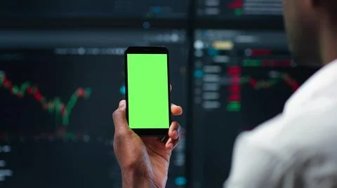 Cropped shot of it-programmer look at green screen cellphone with multiple Stock-Fotos