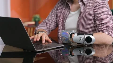 Cropped shot of man with bionic arm work on computer at home. Foto stock