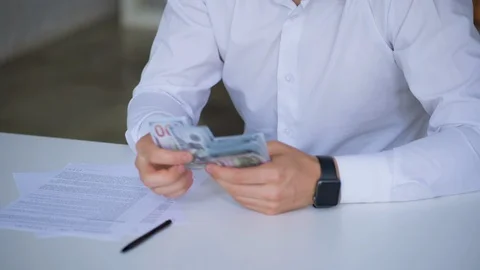 Cropped shot of man counting hundreds of dollars money with hands at the desk Stock Footage 124368315