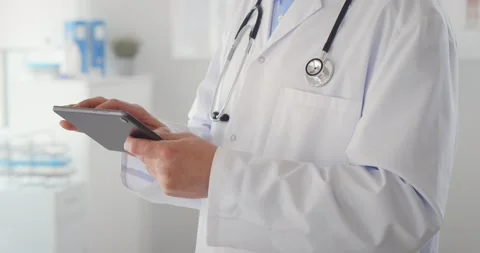 Cropped shot of man doctor checking data on digital tablet Stock Footage 152884060