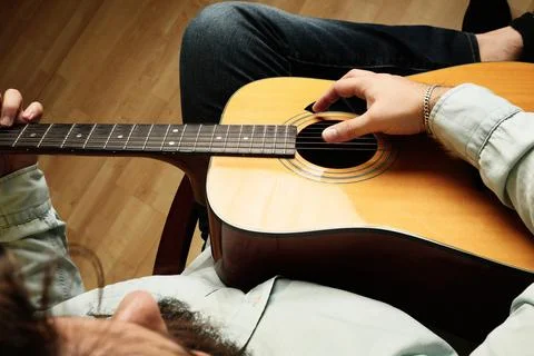 Cropped shot of man practicing in playing acoustic guitar. Top view. Stock-Fotos