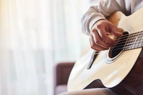 Cropped shot of man practicing in playing acoustic guitar. Close-up of man hand Stock Photos