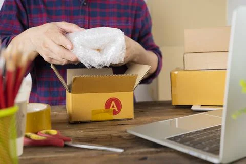 Cropped shot of man preparing a parcel for delivery at online selling busines Stock Photos