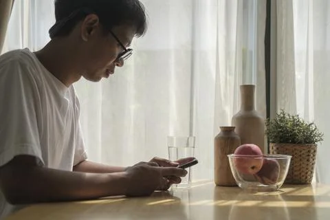 Cropped shot man using smart phone at home. Stock Photos