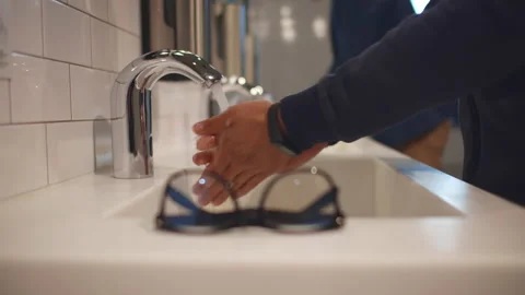 Cropped shot of man washing hands in public restroom. Realtime Stock Footage 233818158