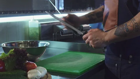Cropped shot of a professional chef sharpening his knife Stock Footage 86159588