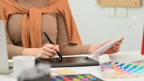 Cropped shot, selective focus on hand. Creative woman using graphic tablet and Stock Photos
