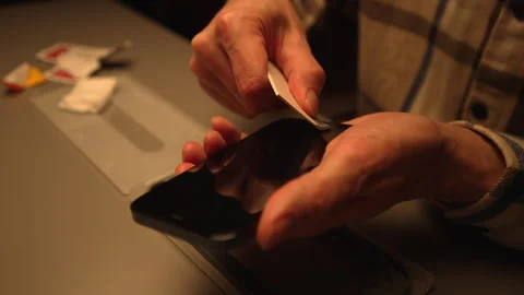 Cropped shot of skilled technician carefully applying screen protector to Stock Footage 302565035