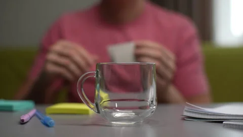 Cropped shot of unrecognizable man opening and putting bag of drip coffee in Stock Footage 297627323