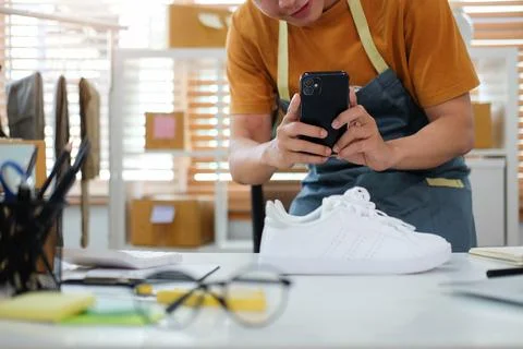 Cropped shot young man using smart phone taking a photo of product for upload Stock Photos