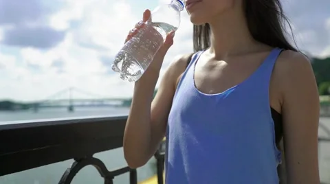 Cropped side shot view of a young charming brunette female jogger holding bottle Stock Footage 65373296