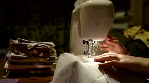 Cropped side view of hands stitching piece of fabric on automatic sewing machine Video stock 46054756