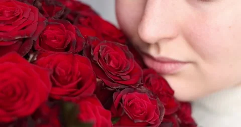 Cropped smiling face lips close-up happy woman hand holding big bouquet of re Stock Footage 300366376