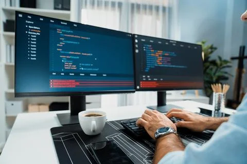 Cropped typing hands IT working software development coding on two pc. Surmise. Foto stock