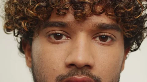 Cropped view of a calm young man with brown eyes looking to camera. Studio Stock Footage 231286661