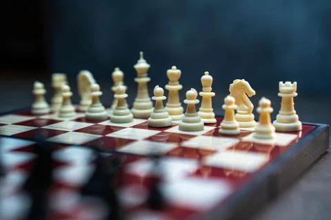 Cropped view of chess board with white chess pieces on rustic wooden surface Stock Photos