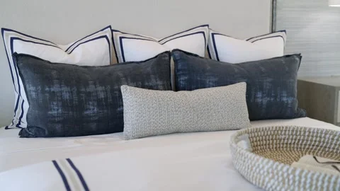 Cropped view of decorative pillows combination laying on white blanket on top of Stock Footage 273832075