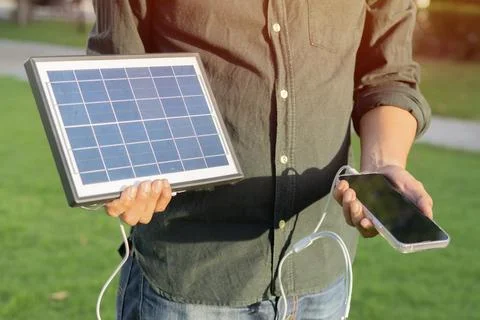 Cropped view of eldery man with a mobile phone standing with solar panels a.. Stock Photos