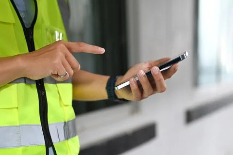 Cropped view of engineer man wearing yellow vest standing in construction site Stock Photos