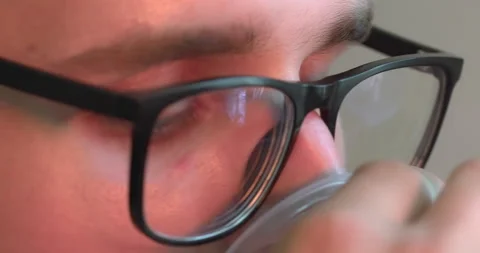 Cropped view of eyes, guy in goggles, brings plastic glass to his face to drink. Stock Footage 223976474