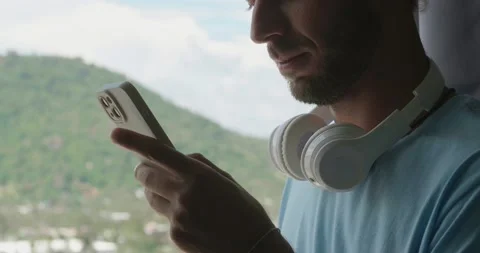 Cropped view of a handsome guy standing by window overlooking beautiful Stock Footage 219951251
