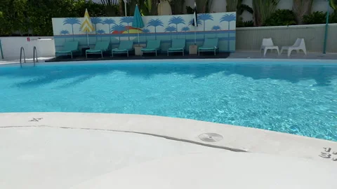 Cropped view of man putting cocktail on white surface near swimming pool 库存影片 132644397