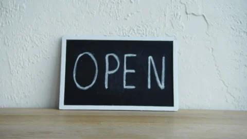 Cropped view of man putting coffee to go in front of open signboard 库存影片 133781296