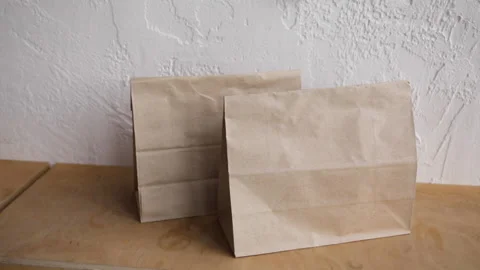 Cropped view of man in putting disposable cup on wooden surface near paper bags Stock-Footage 132445788