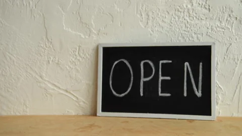 Cropped view of man putting disposable cup and paper bag near open signboard Stock-Footage 133782660