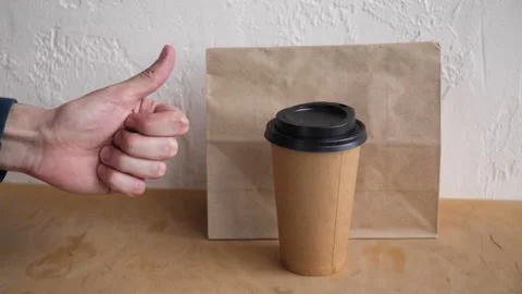 Cropped view of man showing thumb up near takeaway paper bag and disposable cup Stock-Footage 132445678