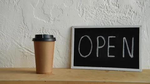 Cropped view of man taking disposable cup near open signboard Stock-Footage 133779742