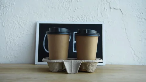Cropped view of man taking disposable cups near open signboard 库存影片 133781381