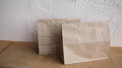 Cropped view of man in taking paper bags from wooden surface Stock-Footage 132445040