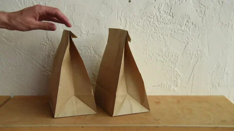 Cropped view of man taking paper bags from surface 库存影片 133780652