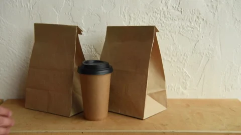 Cropped view of man taking paper bags and disposable cup 库存影片 133783566