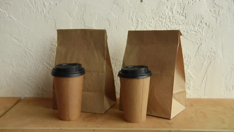 Cropped view of man taking paper bags and disposable cups 库存影片 133784804