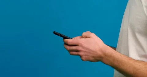 Cropped view of man typing on smartphone isolated on blue background Stock Footage 123967915