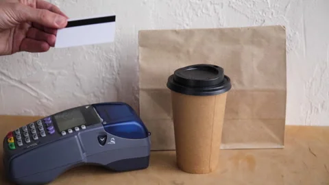 Cropped view of man using credit card and payment terminal near paper bag 库存影片 132445873