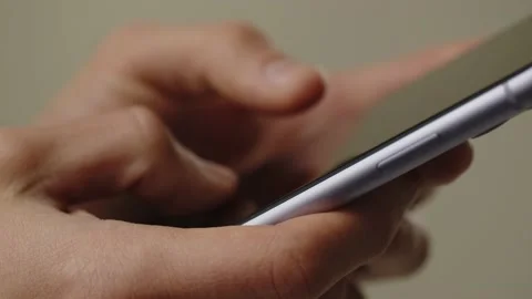 Cropped view of a man using his smartphone. A man holds a smartphone in his Stock Footage 236563657
