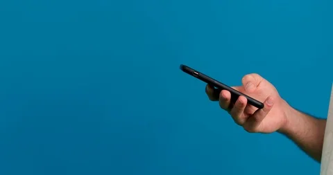 Cropped view of man using smartphone isolated on blue background Vídeos de archivo 124904902