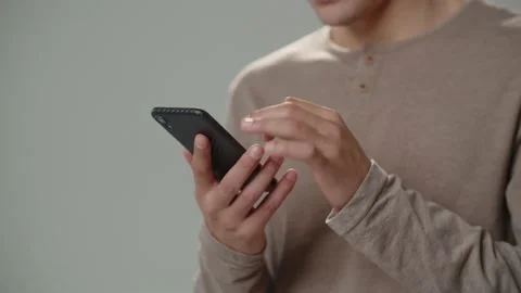 Cropped view of man using smartphone.Man taps and scrolls with finger on Stock Footage 234325330