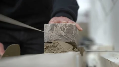 Cropped View Of A Mason Laying Brick On Construction Site. Close Up Vidéo 220868002