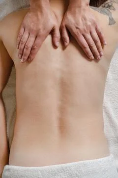 Cropped view of masseur doing back massage to woman on massage mat Stock Photos