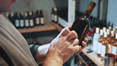 Cropped view of the professional winemaker holding bottle of red wine while Stock Footage 147801127