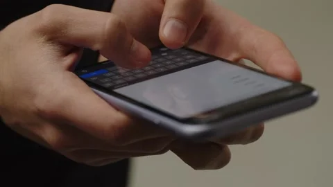 Cropped view of a smartphone user tapping on the screen. Male hands typing a Stock Footage 236643851