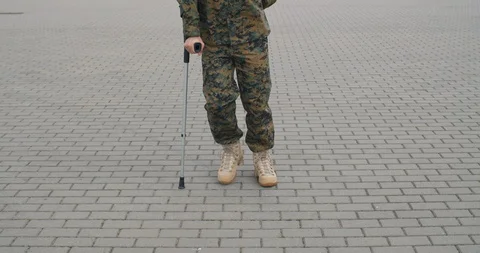 Cropped view of soldier limping and leaning on crutch Stock Footage 121607193