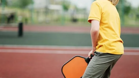 Cropped view unrecognizable boy playing pickleball game, hitting pickleball Видео 244049565